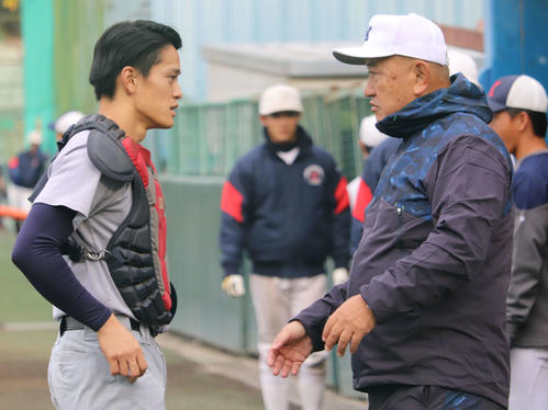 捕手とコミュニケーションをとる慶大・堀井新監督（撮影・金子真仁）
