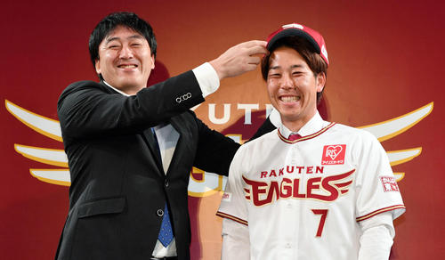 楽天入団会見で石井GM（左）から帽子をかぶせてもらう鈴木（2019年11月27日）