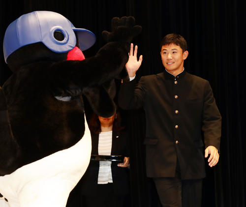 ヤクルト新入団選手発表会でつば九郎とハイタッチで入場する奥川（撮影・浅見桂子）