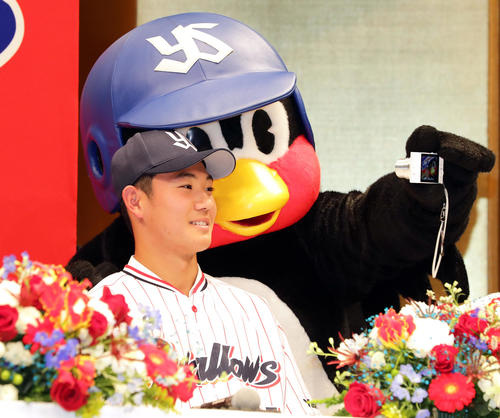 ヤクルト新入団選手発表会で、つば九郎と記念撮影する奥川（撮影・浅見桂子）