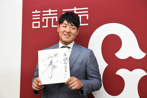 契約更改後の会見で来季の目標を書いた色紙を手にする巨人岡本（撮影・山崎安昭）