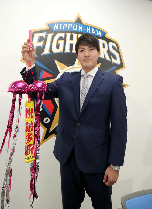 最多勝のくす玉を持ちながら撮影に応じる日本ハム有原（撮影・佐藤翔太）