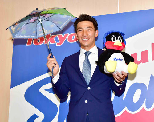 嶋はヤクルトと正式契約しビニール傘とつば九郎のぬいぐるみを手に笑顔を見せる（撮影・小沢裕）