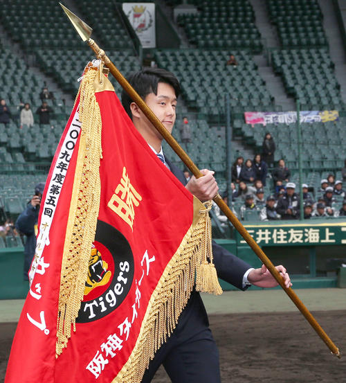 タイガースカップ表彰式のプレゼンターを務め優勝旗を持つ小幡（撮影・上山淳一）