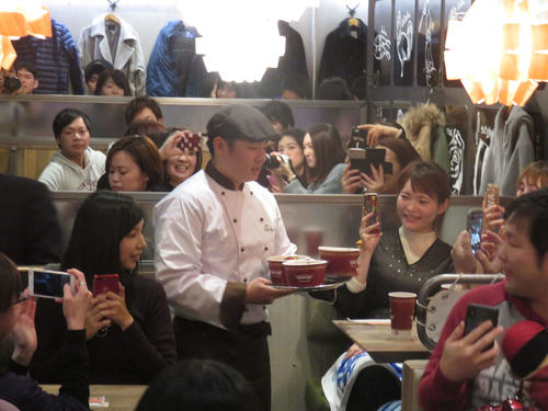「6KenKitchen」でのイベントでシェフ姿の楽天松井は、ローストビーフ丼をお客さんへ配膳する（撮影・桑原幹久）