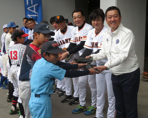 巨人原監督（右）らは子どもたちから野球道具を受け取る