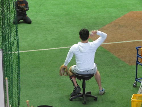 椅子に座って、キャッチボールする巨人野上（撮影・久保賢吾）