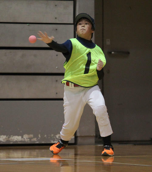手をバットの代わりにして手でボールを打つ参加した小学生