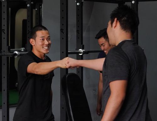 アリゾナの施設で西武田村（左）と自主トレをするマリナーズ菊池は、笑顔でタッチをする（撮影・菅敏）