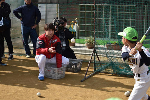 母校・連島南小学校のグラウンドで行われた野球教室で、少年にボールをトスする広島野村