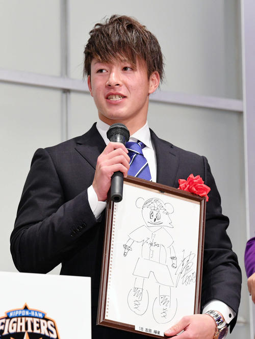 懇親会のお楽しみ抽選会で自身が描いた球団マスコットの絵を手にする日本ハム吉田輝（撮影・滝沢徹郎）