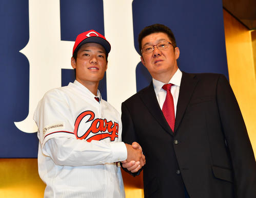 広島の新入団選手発表で佐々岡真司監督（右）と握手を交わす韮沢雄也（撮影・清水貴仁）