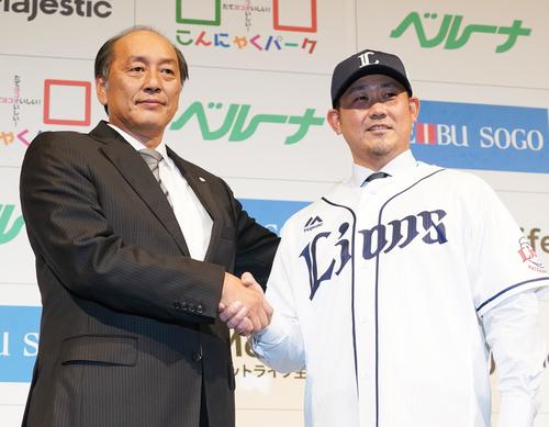 14年ぶりに西武に復帰する松坂大輔は、入団会見でユニホームに袖を通し、渡辺GM（左）と笑顔で握手をする（撮影・菅敏）