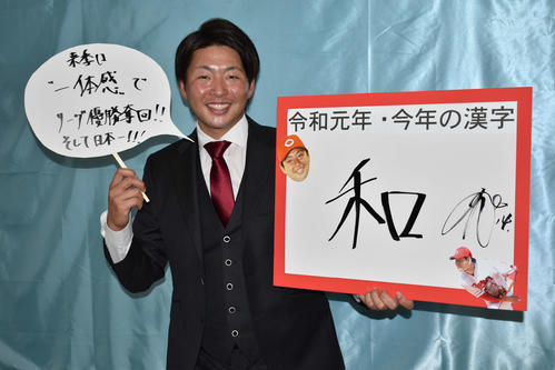 契約更改を終え、今年の漢字に「和」と書いたボードを掲げ、写真撮影に応じる大瀬良
