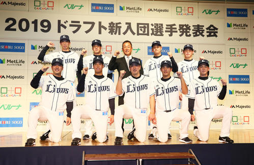 西武新入団選手たちは辻監督（後方中央）を囲んだ記念撮影に笑顔を見せる。前列左から柘植、松岡、宮川、浜屋、川野、後列左から出井、上間、1人おいて井上、岸（撮影・足立雅史）