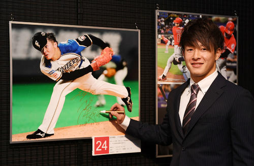野球殿堂博物館での報道写真展にゲストで来場した日本ハム吉田は写真パネルにサインを書く（撮影・山崎安昭）