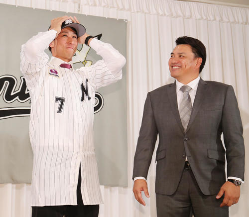 ロッテ入団会見で井口監督（右）から手渡された帽子を笑顔でかぶる福田（撮影・垰建太）
