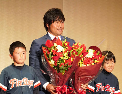 激励会パーティーで子どもたちから花束を贈られた平田（撮影・森本幸一）