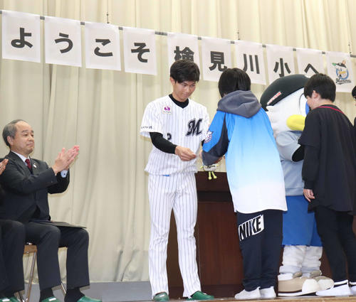 検見川小学校の児童に「マリーンズ算数ドリル」を手渡すロッテ藤原（撮影・久永壮真）