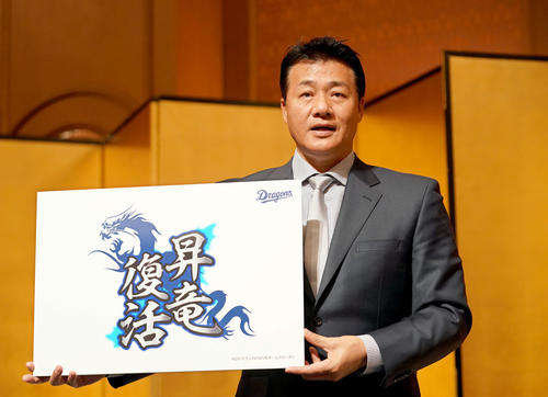 来季のチームスローガンを記したパネルを手に笑顔を見せる与田剛監督