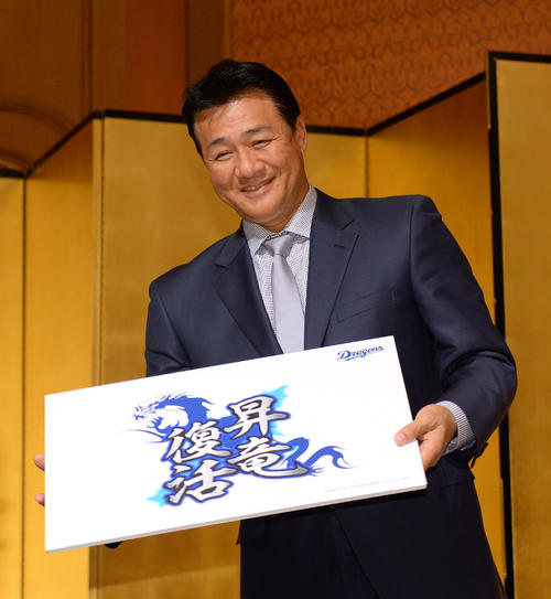 来季のチームスローガンを記したパネルを手に笑顔を見せる与田剛監督