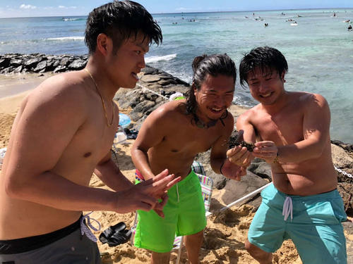 ワイキキビーチでかにを捕まえ大喜びのソフトバンク甲斐野（左）右は長兄の祐大さん、中央は次兄の耕一さん