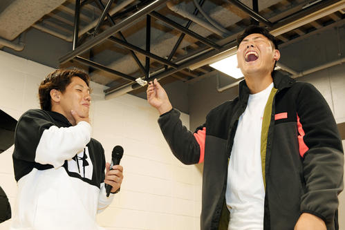 アンダーアーマー社のイベントでオリックス吉田正（左）へ結婚を控えサプライズでプレゼントされたケーキを口に運び爆笑する巨人岡本（撮影・滝沢徹郎）