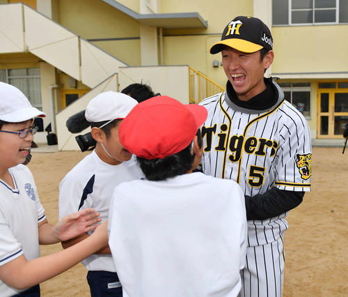 摂陽小学校を訪れ児童と笑顔で握手を交わす近本光司（撮影・上田博志）