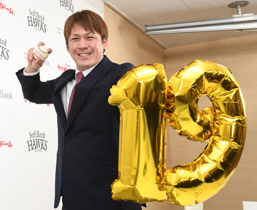 推定1億1000万円で契約を終え、来季の背番号「19」を持ち笑顔のソフトバンク甲斐拓也（撮影・今浪浩三）