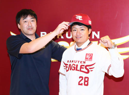 楽天に加入し会見に臨んだ酒居（右）は石井GMから帽子をかぶせてもらう（撮影・足立雅史）