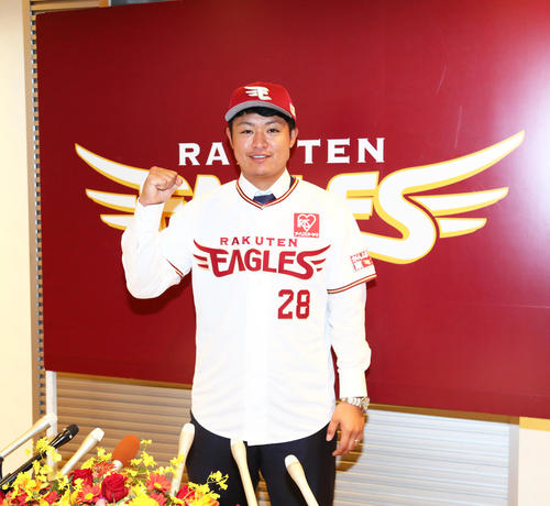楽天に加入し会見に臨んだ酒居はユニホーム姿で笑顔を見せる（撮影・足立雅史）