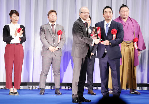 報知プロスポーツ大賞で、トロフィーを受け取る巨人の阿部（右）。左は報知新聞社・丸山社長。後列左は渋野（撮影・浅見桂子）