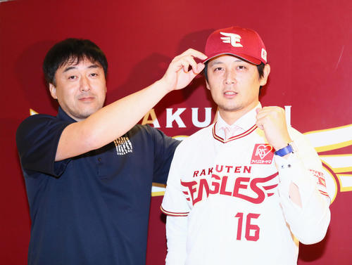 楽天に加入した涌井（右）は石井GMから帽子をかぶせてもらう（撮影・足立雅史）