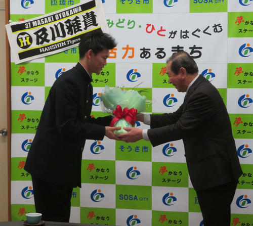 千葉県匝瑳市役所を訪れ、太田安規市長を表敬訪問し、花束を受け取る阪神ドラフト3位の及川雅貴投手（左）。右は太田市長（撮影・磯綾乃）