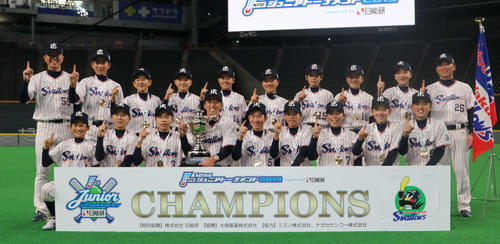 優勝し、ナンバーワンポーズをとるヤクルトジュニアのナインと首脳陣（撮影・山崎純一）