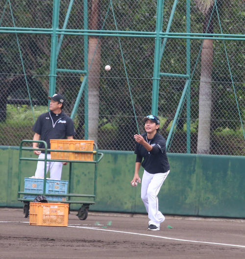 沖縄・国頭での秋季キャンプでゴロ捕球の練習でボールをトスする武田投手コーチ（右）