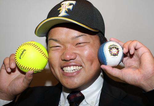 11年10月27日、ドラフト7位指名にソフトボールと日本ハム球団球を手にする大嶋