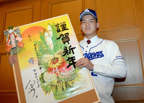 真新しいサインを記した年賀状を手に笑顔の石川（撮影・森本幸一）