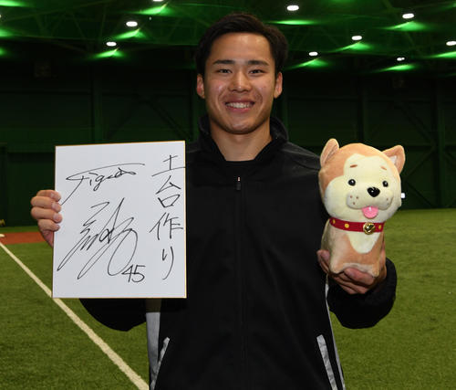 秋田犬を手に今季の目標を色紙にしたためた阪神・遠藤（撮影・前岡正明）