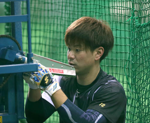 調子が悪いピッチングマシンの手入れをする日本ハム松本（撮影・佐藤翔太）
