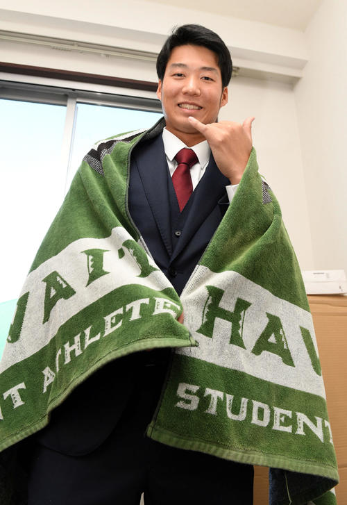 入寮した楽天ドラフト育成3位の山崎はハワイ大のタオルに身を包みポーズを決める（撮影・滝沢徹郎）
