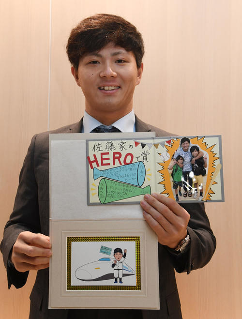 プレゼントされた似顔絵らを持って入寮したドラフト1位の佐藤（撮影・今浪浩三）