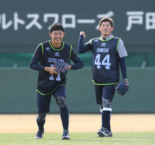 ノックの合間に笑顔を見せるヤクルトドラフト1位の奥川（左）。右は大西（撮影・鈴木みどり）