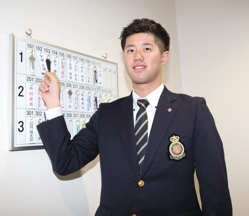 入寮した広島ドラフト2位の宇草孔基はネームプレートを手に笑顔（撮影・梅根麻紀）