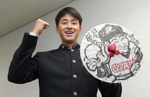 ジャイアンツ寮に入寮し、自身の似顔絵が描かれた花巻傘を手に笑顔を見せる巨人ドラフト1位の堀田（撮影・加藤諒）
