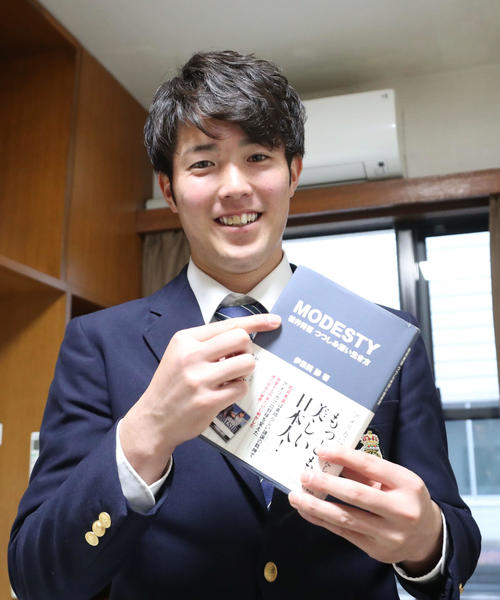 入寮した森下は持ち込んだ書籍を手に笑顔を見せる（撮影・梅根麻紀）