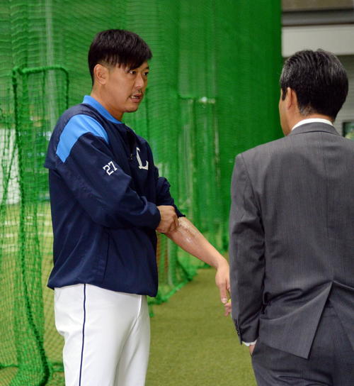 19年11月、西武内海（左）は左腕の手術痕を見せながら編成グループ潮崎ディレクターに経過を報告する
