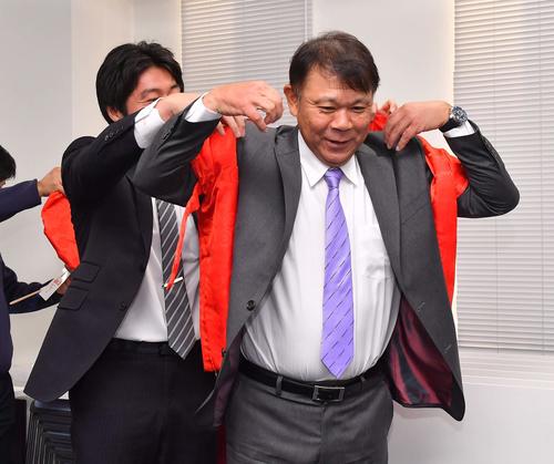 60歳の誕生日を迎え記者から送られた赤いちゃんちゃんこを着て笑顔を見せるオリックス西村徳文監督（撮影・上田博志）