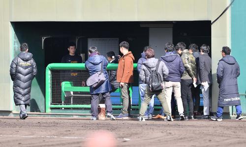 ベンチの川藤幸三阪神OB会長に声を掛けられる井上広大。左は田中秀太スカウト（撮影・上田博志）