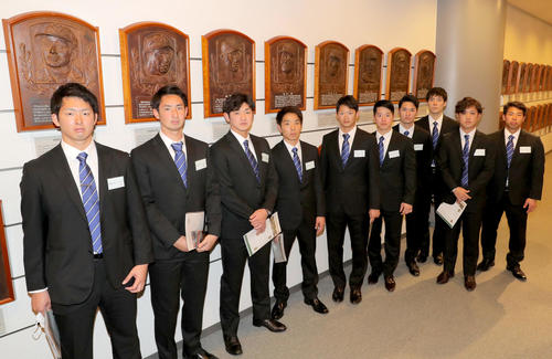 肖像レリーフ（張本勲さんら）の前で記念撮影する日本ハムの新人選手たち（代表撮影）